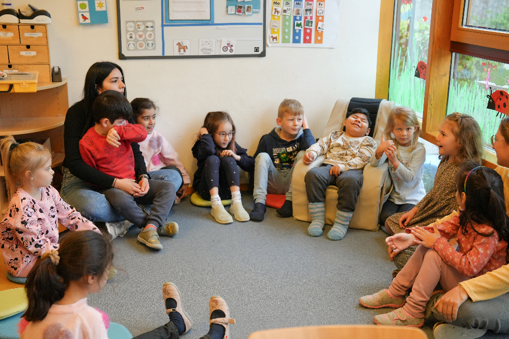 Eine Gruppe von Kindern sitzt in Kreis im Kindergarten Morgentau