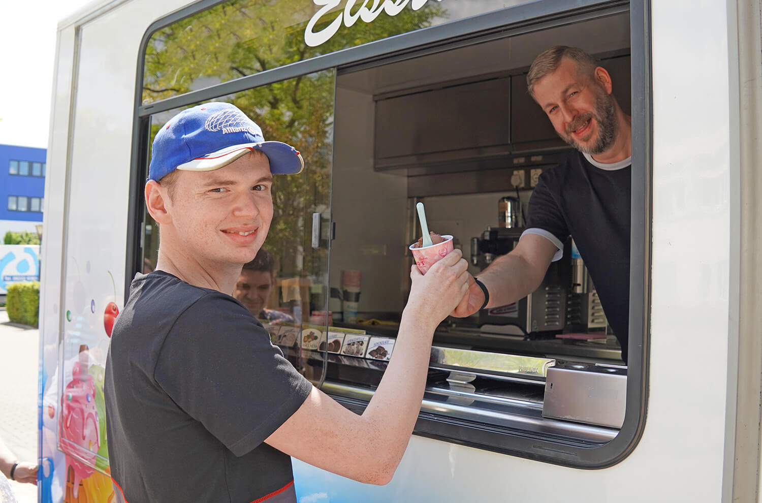 Klient bekommt einen Becher mit Eis am Fenster des Eiswagens