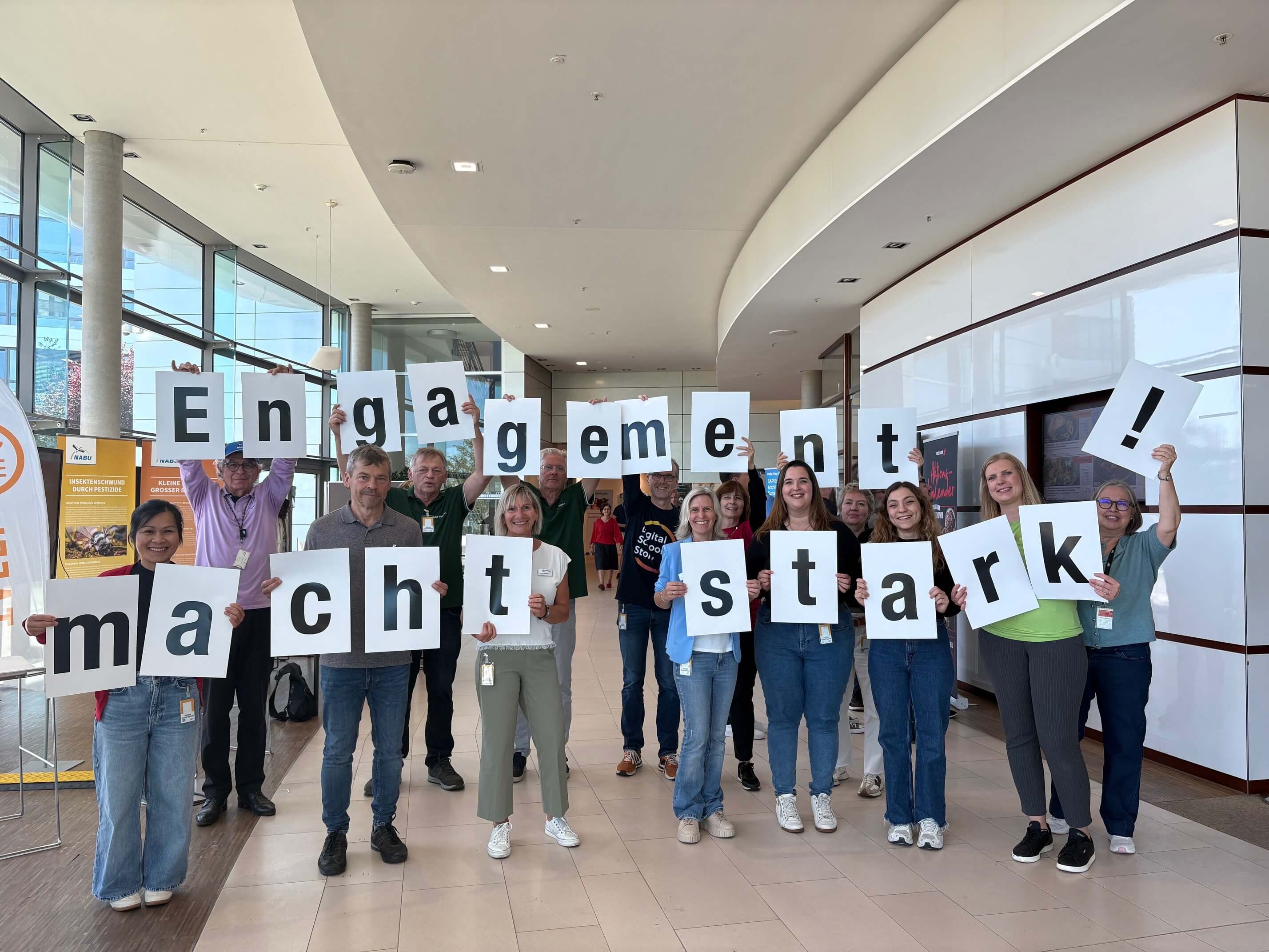 Menschen mit Buchstabenschildern, den den Satz Engagement macht stark zeigen